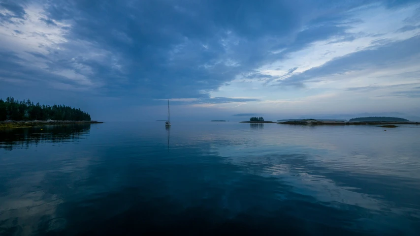 a boat is seen out on the water under a cloudy sky