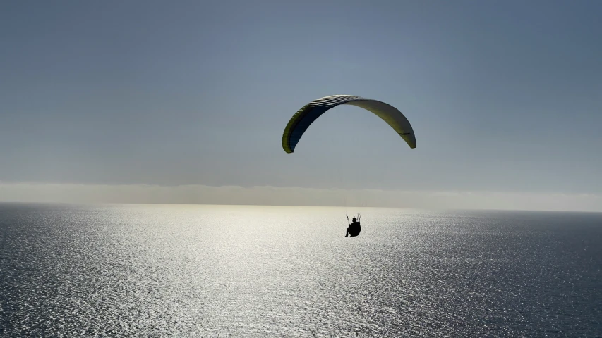 person parasailing over the ocean on a clear day