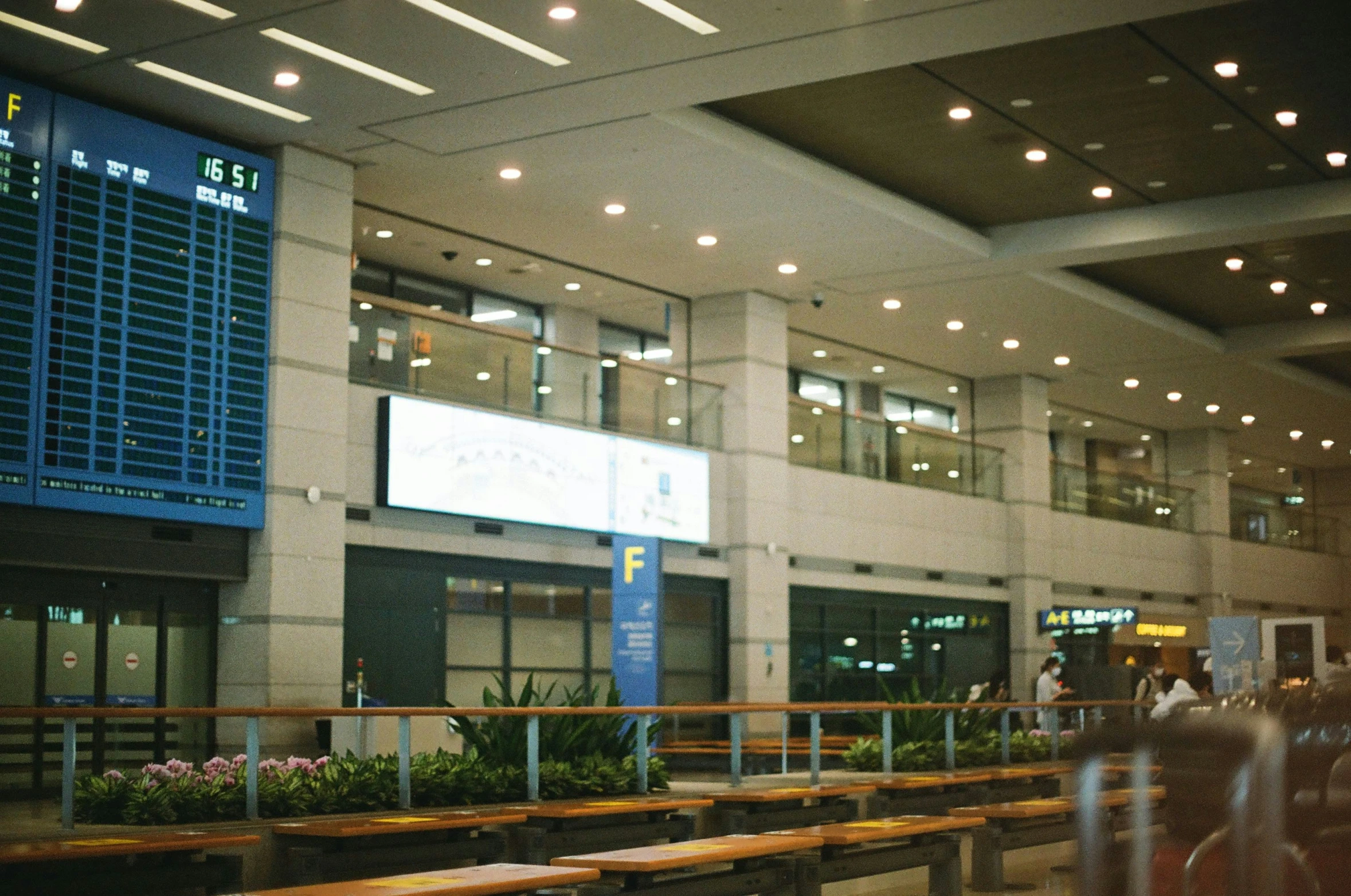 people stand in a lobby at an airport terminal