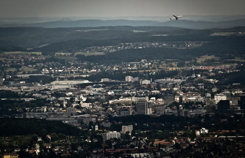 an aerial s shows the city and airplane flying over it