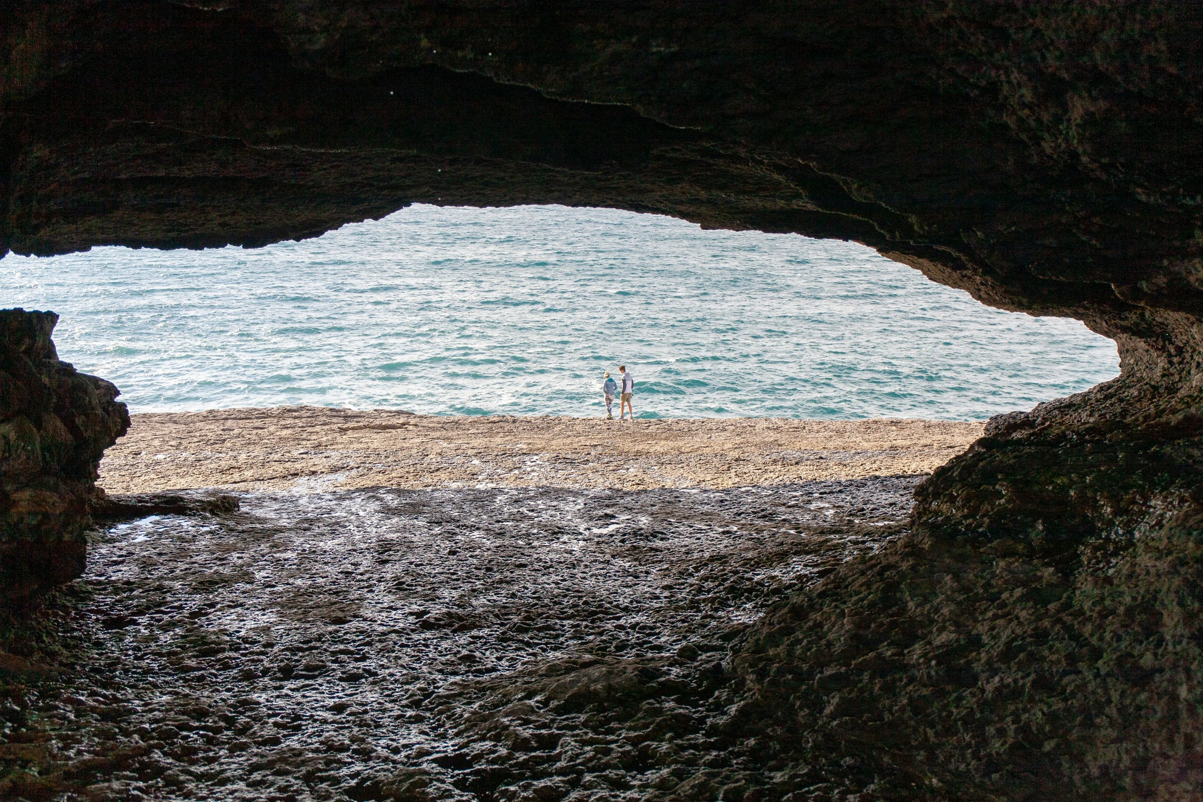 a man stands in the entrance to a cave