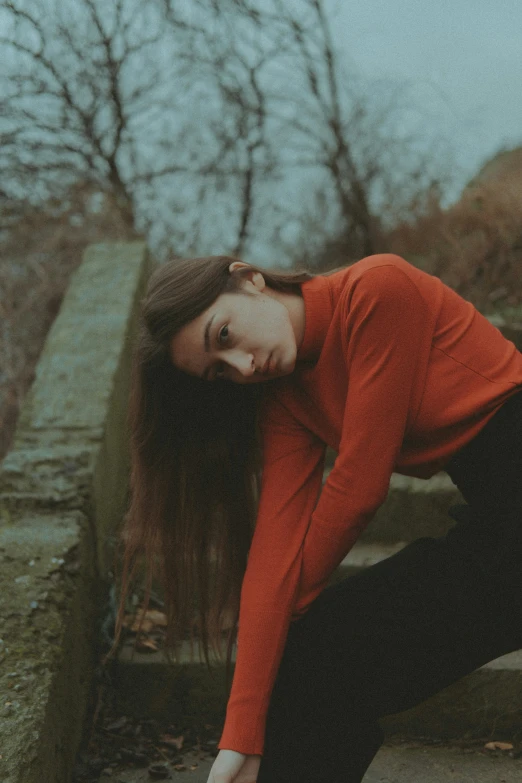 a young lady is posing for a picture in the park