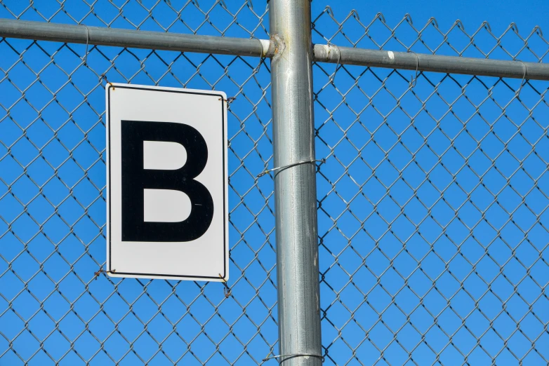 a sign hanging on a chain link fence that reads b