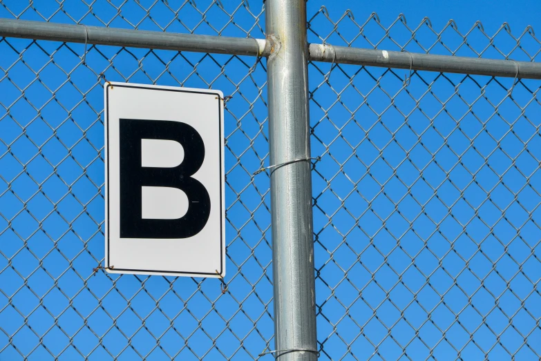a sign hanging on a chain link fence that reads b