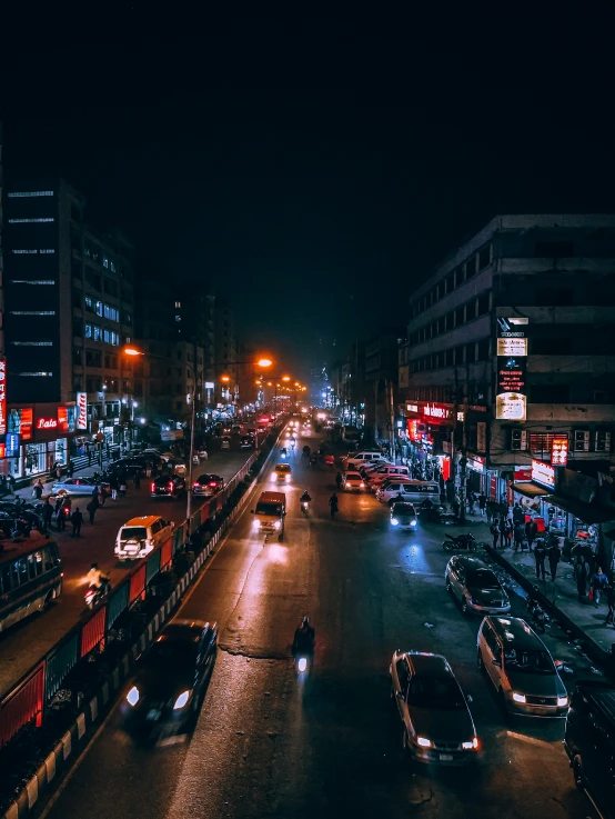 a city at night with cars driving down the street