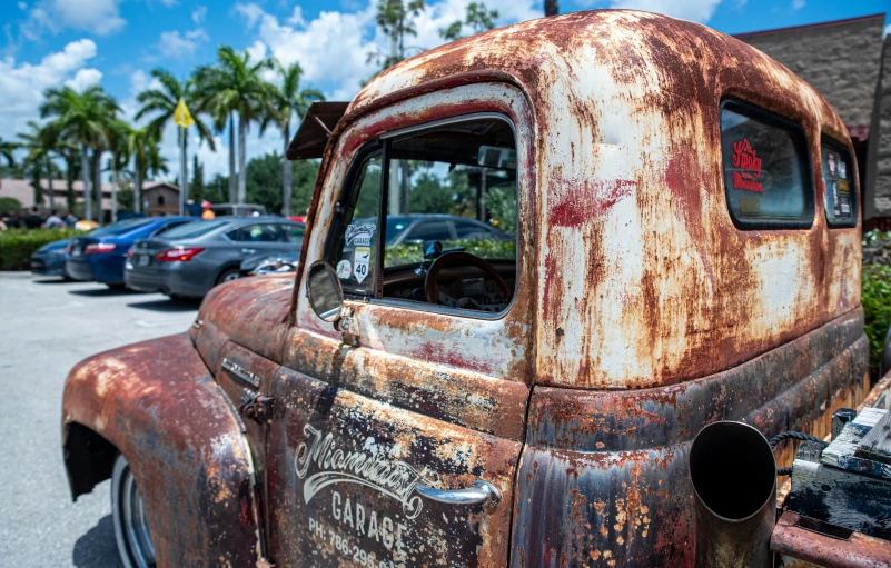 an old rusty car sitting in the lot