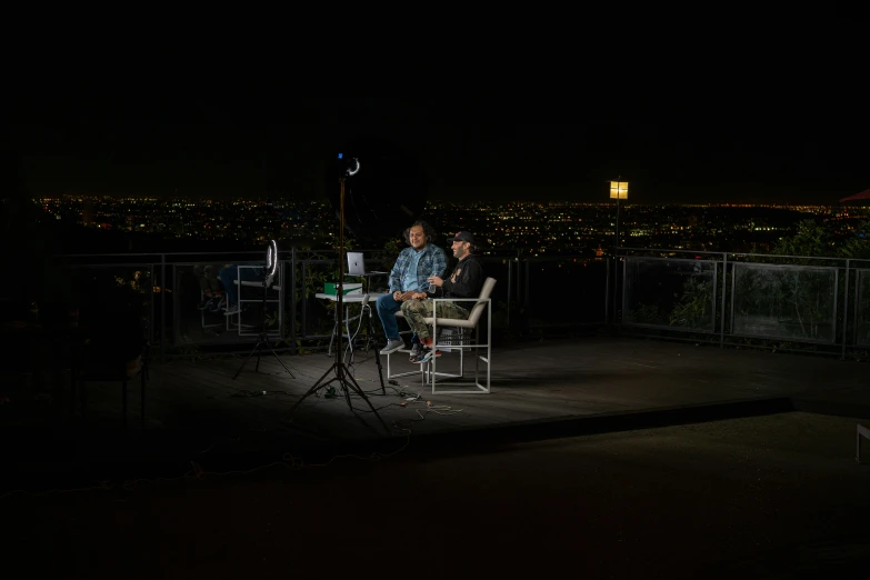 two people sitting at tables on the deck