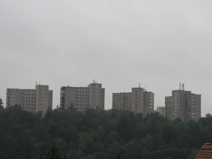 several buildings and trees against a cloudy sky