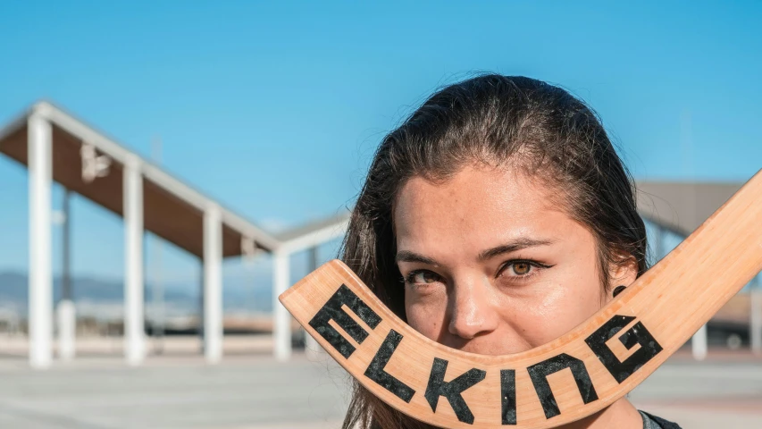 the woman is holding a wooden stick in her mouth