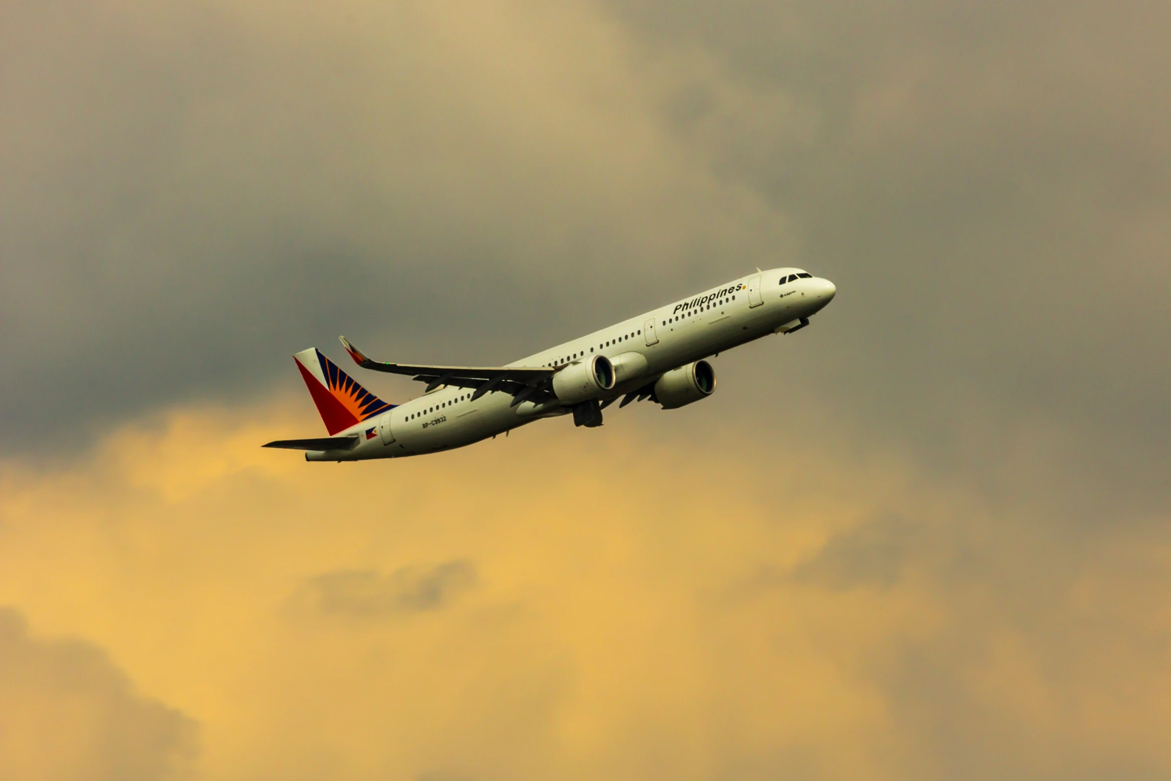 an airplane flying through the sky in a cloudy sky