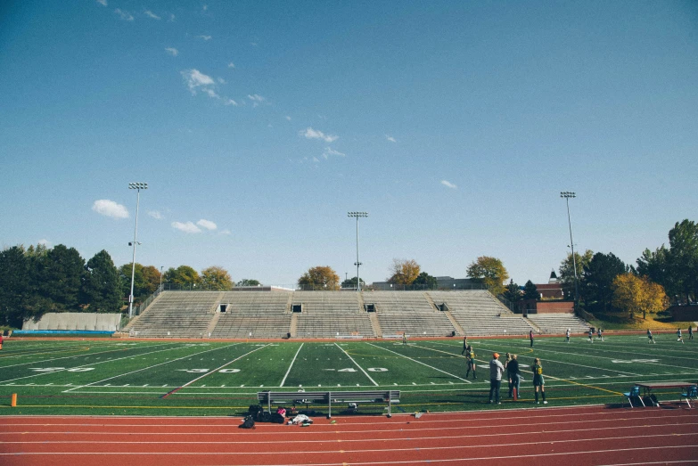 a wide open grassy field with lots of people in the background