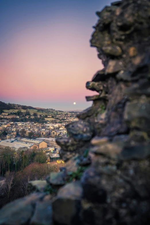 a stone wall with the view of a city in the distance