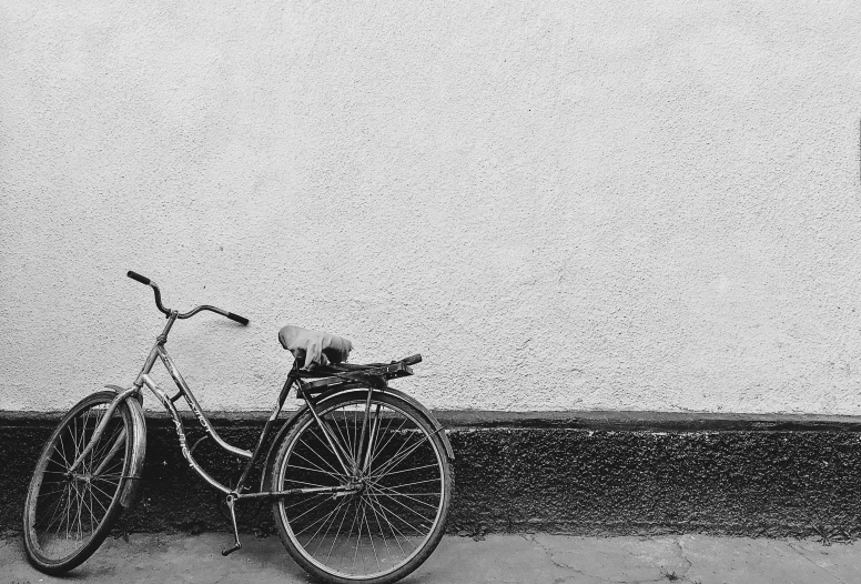 an old bicycle in front of a dirty wall