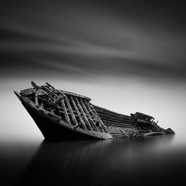 a boat sitting on the shore surrounded by water