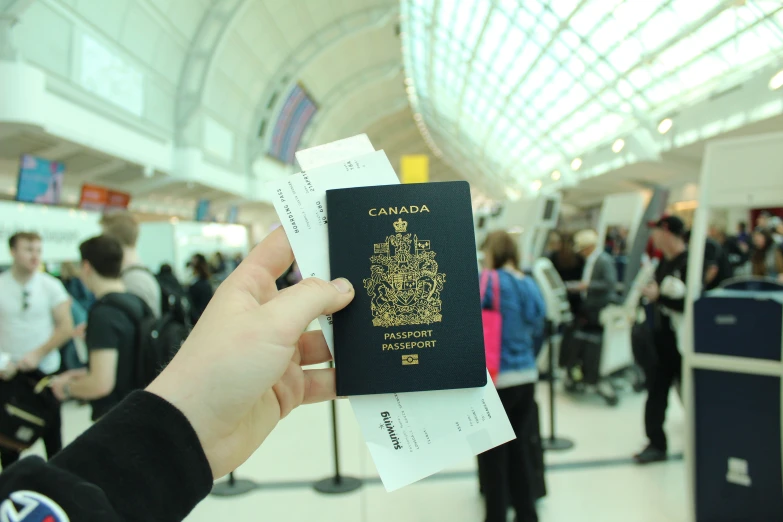 a person holds up a passport at an airport