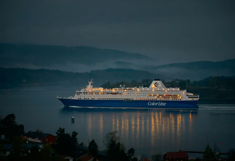 a big ship traveling through the water at night