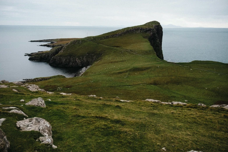 an island is near the water with a grass slope