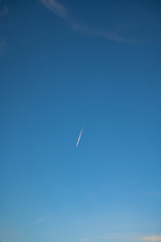 the plane is flying high in the sky with no clouds