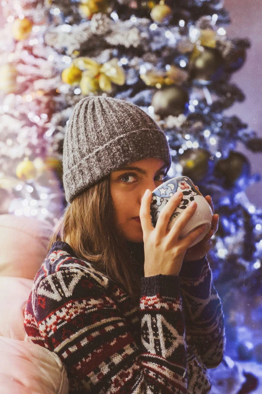 a person taking a po with a camera near a christmas tree