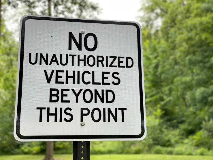 a no unauthhered vehicles beyond this point sign