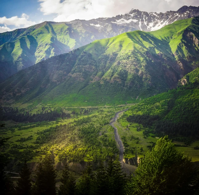 the green mountains and valleys are near the road