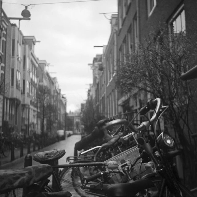 black and white po of bicycles lined up on the side of a building