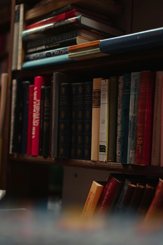 books on a wooden shelf next to a table