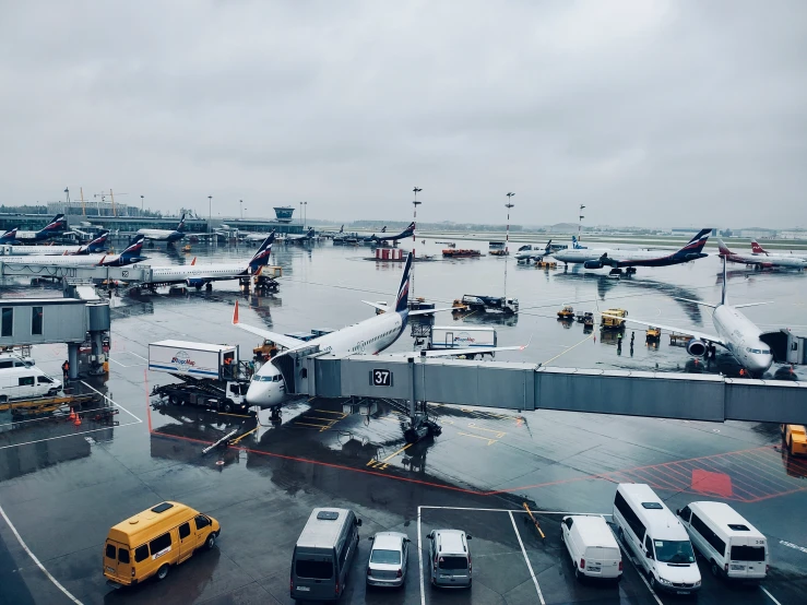 airport terminal in a rainy cloudy sky with planes parked on tarmac