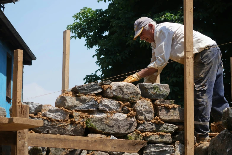 a man is standing over a pile of rocks