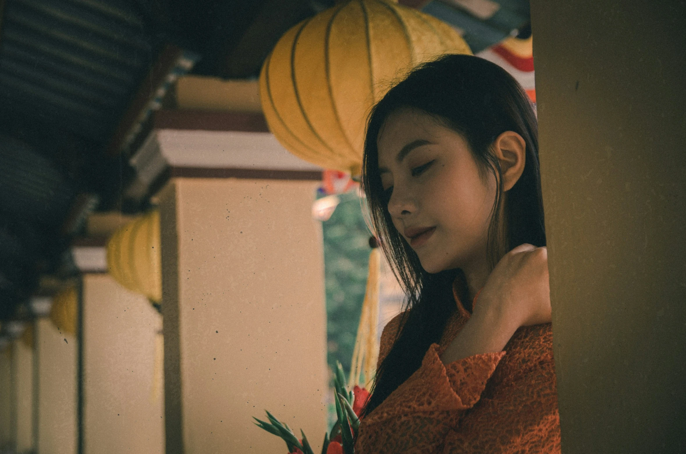 a woman in a orange top stares over her shoulder