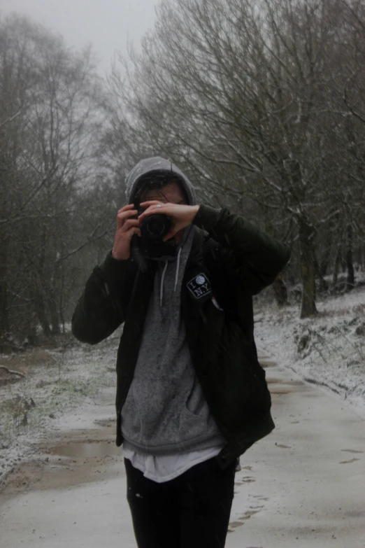 a man taking a picture while wearing a hat