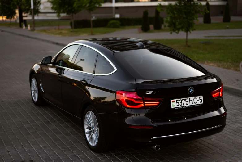 a black car is parked on the side of the road