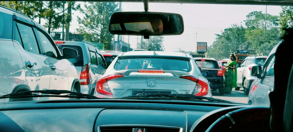 cars traveling on the road near a green sign