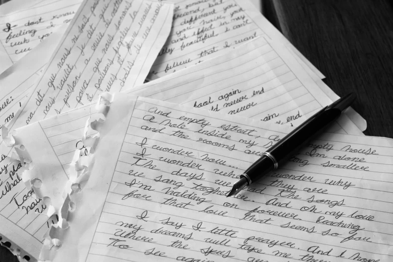 a desk with papers and a pen laying on top of it