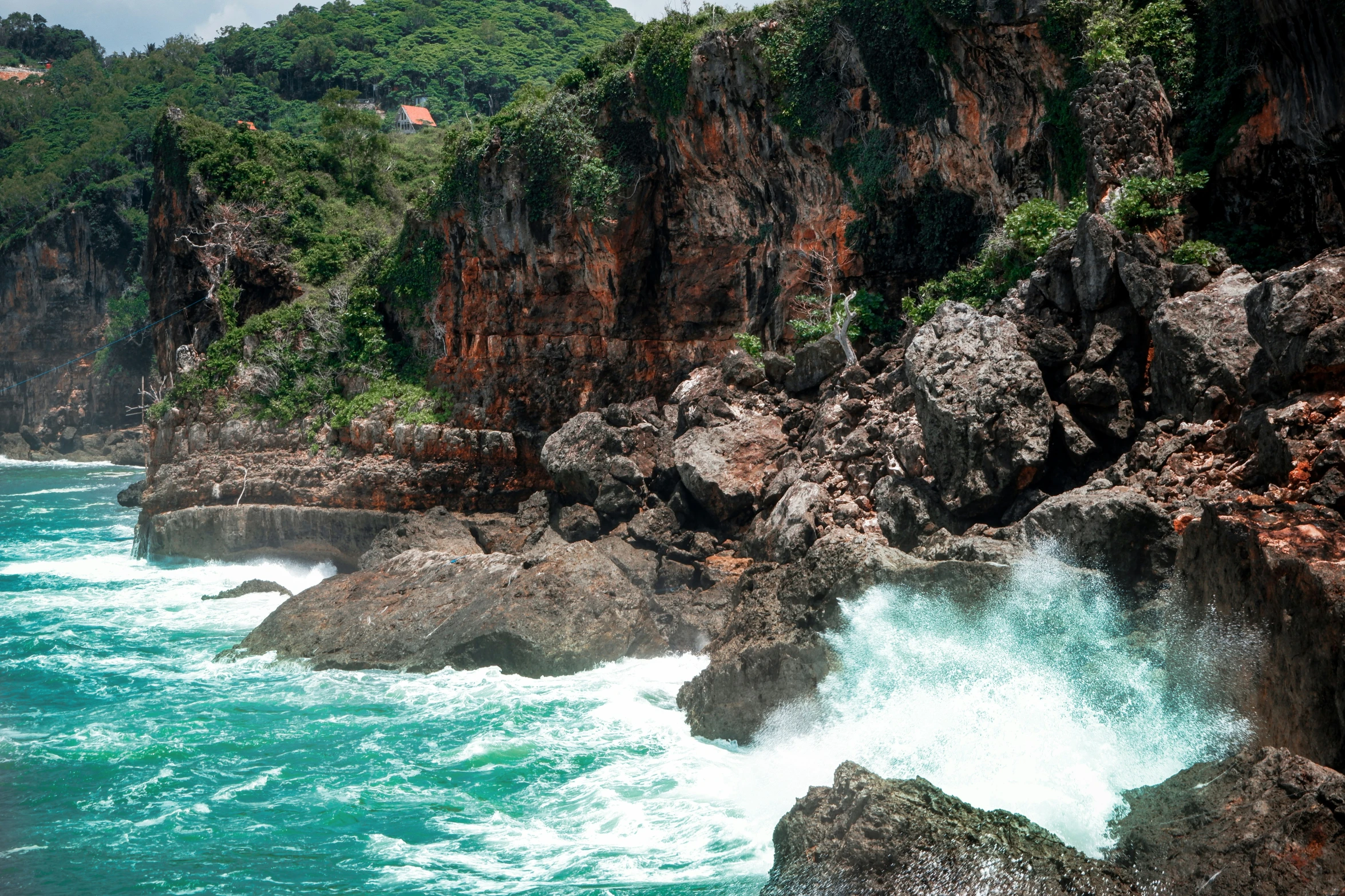 some rocks and blue water by the shore