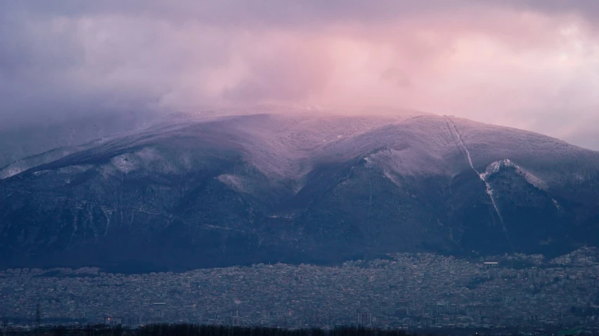 there is a mountain peak in the background as clouds are covering it