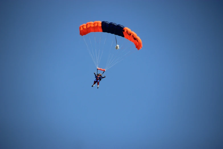 an orange and black parachute being pulled by a parachute