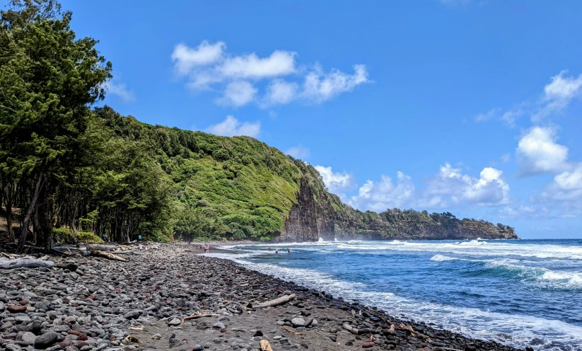 a rocky beach with a boat on the water