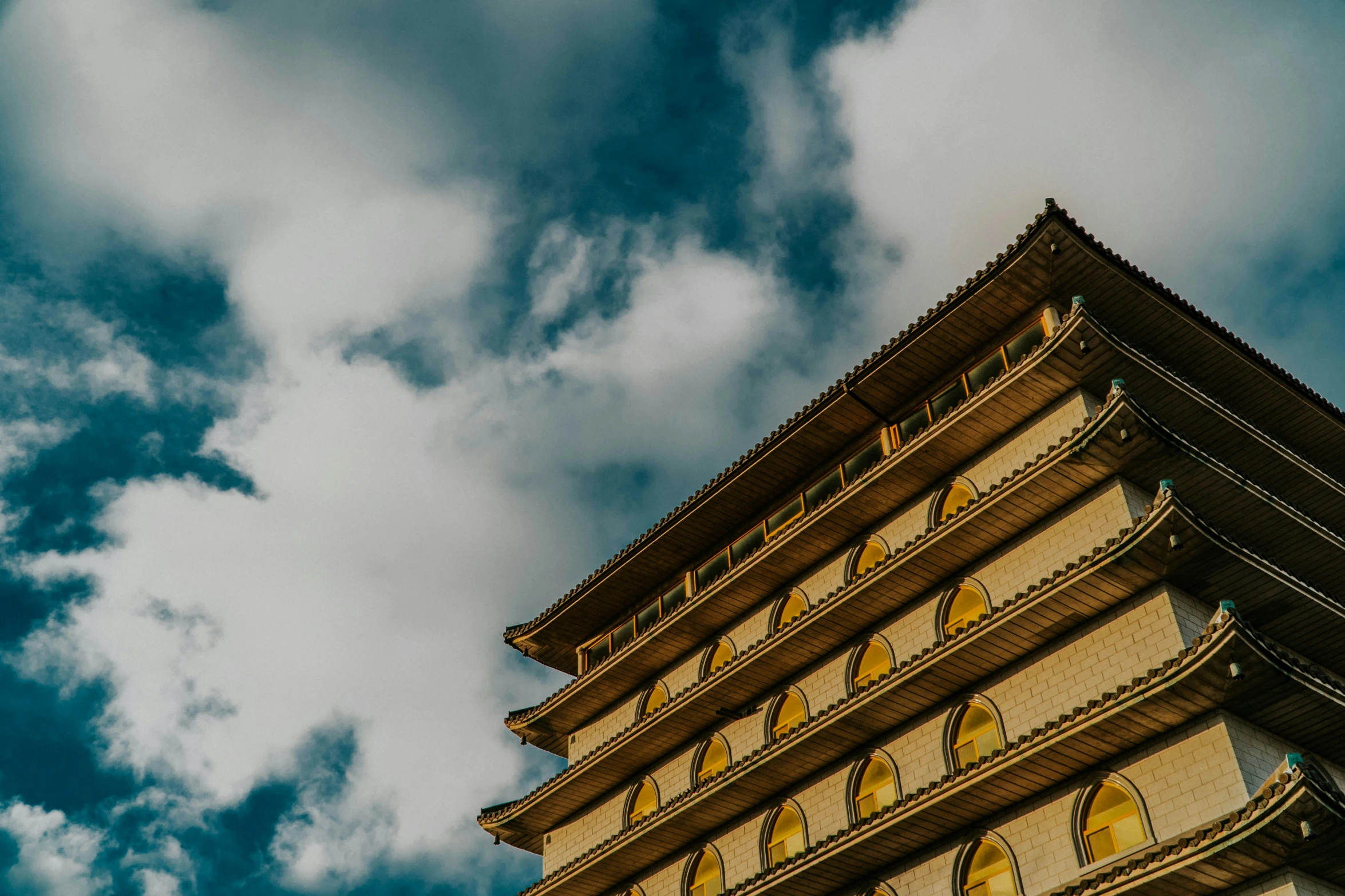 a tall building under a cloudy blue sky