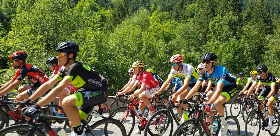 a large group of people riding bikes down a road