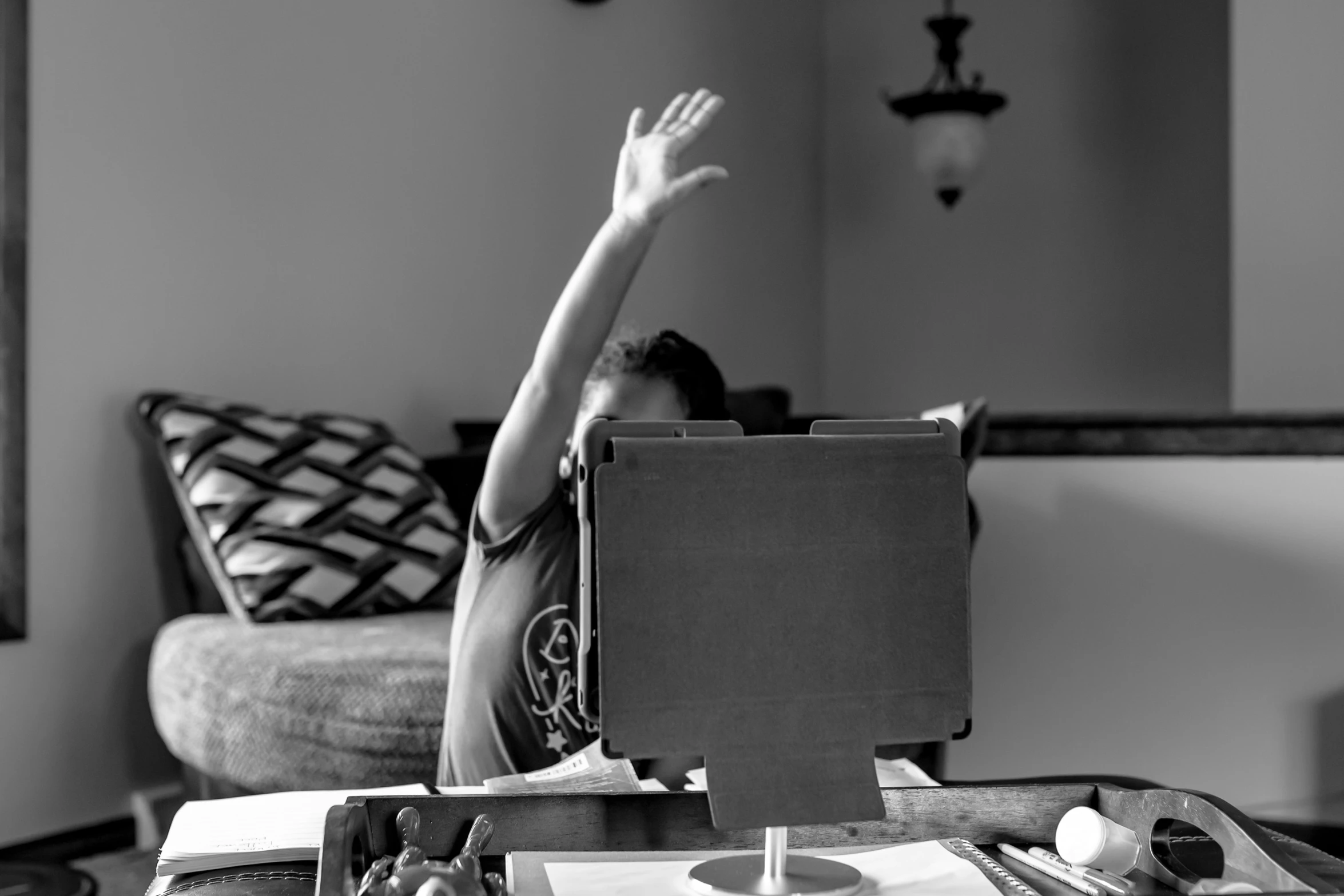 a man that is sitting in a chair waving