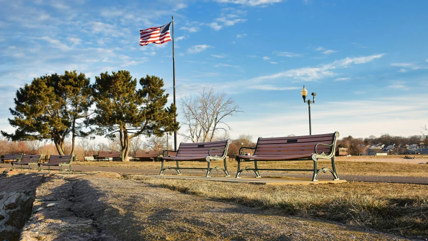 several empty benches and a flag flying in the background