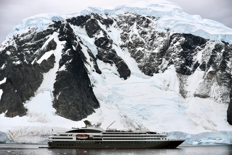 the yacht is in front of the large mountain