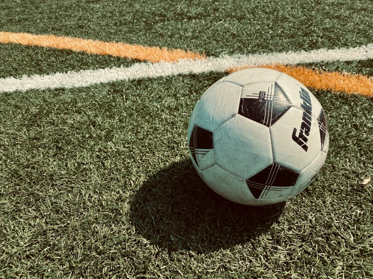 soccer ball on artificial turf next to white stripe