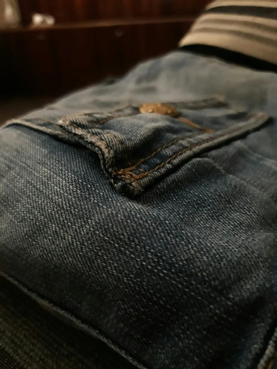 the bottom section of a pair of jeans, with one on up on the lap