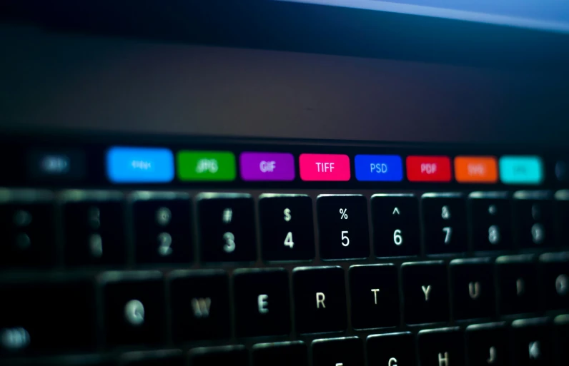 a keyboard that is in the dark with several colors