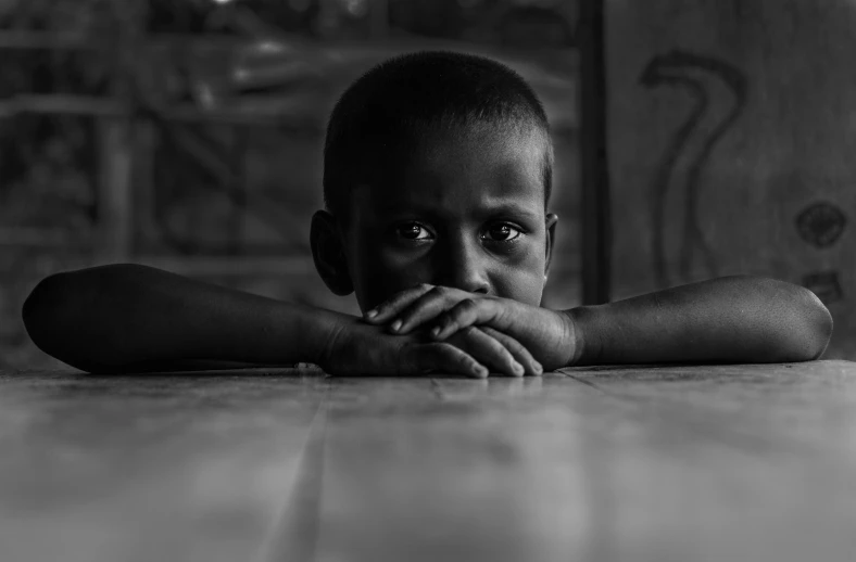 young african american child sitting on the floor and looking over his shoulder