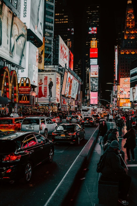 some traffic on a busy city street with large billboards