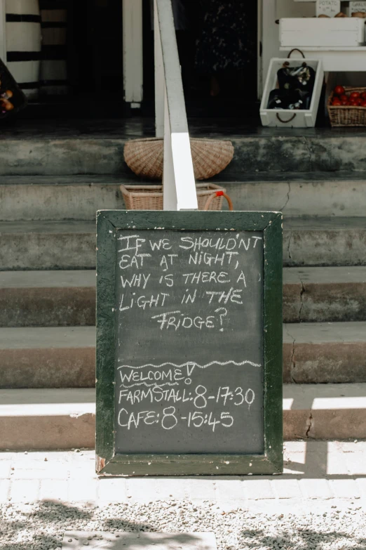 a chalkboard sign with writing on it near steps