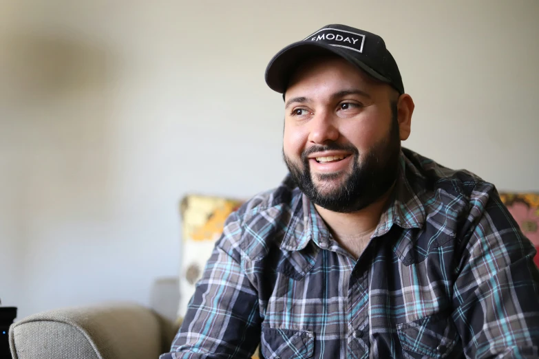 a man is sitting on the couch smiling